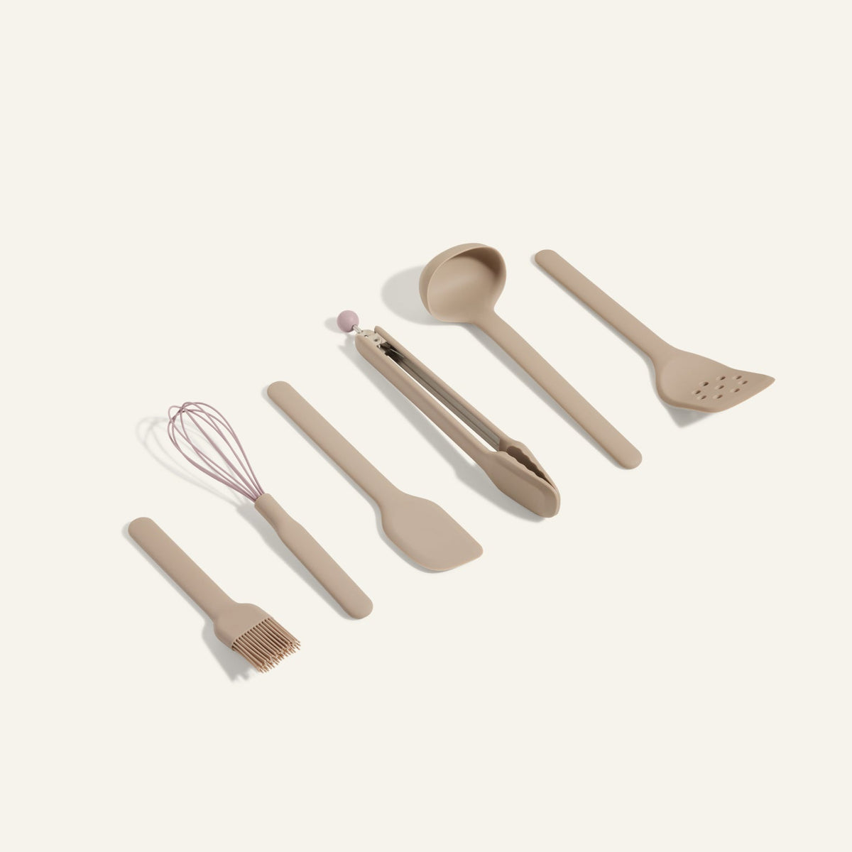 Utensil Essentials is a set of six beige cooking tools—pastry brush, whisk, spatula, tongs, ladle, and slotted spatula—arranged on a light background and ideal for everyday use in the kitchen.