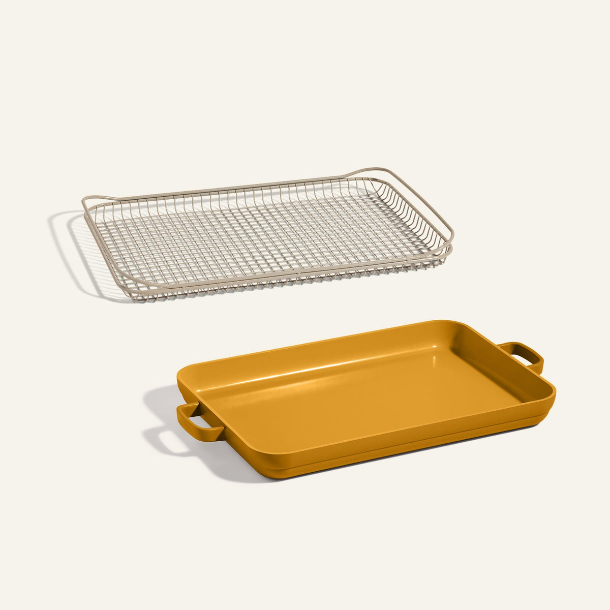The Oven Rack + Griddle Pan set, featuring a yellow rectangular griddle pan with handles and a matching wire rack, is displayed on a neutral background.