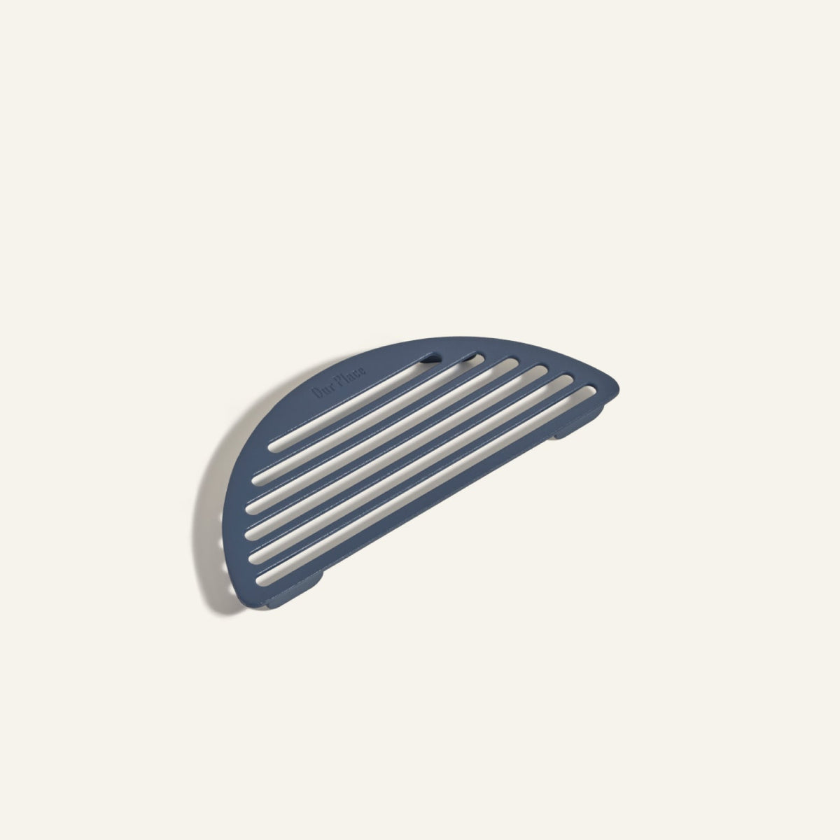 A blue, semicircular plastic Fry Deck with horizontal grooves, inspired by the sleek Our Place cookware design, photographed on a plain light background.
