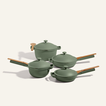 The non toxic cookware set - pots and pans set features four green pots and pans with wooden handles and matching lids, displayed on a neutral background.
