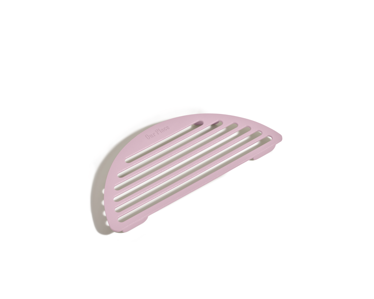 A pink, semi-circular slotted soap dish is displayed on a white background, featuring a design similar to Our Place's Fry Deck.