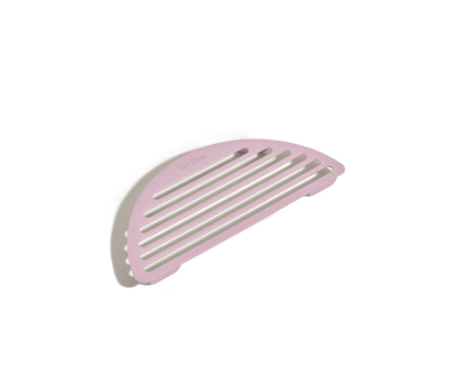 A pink, semi-circular slotted soap dish is displayed on a white background, featuring a design similar to Our Place's Fry Deck.