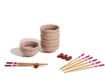 The Rice Bowl Set includes four pink patterned stoneware bowls, matching chopsticks with red and white tips, and red rests—ideal for your Lunar New Year table setting.