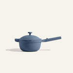 The Mini Perfect Pot 2.0 in matte blue, featuring a lid and long handle, is displayed against a plain off-white background.
