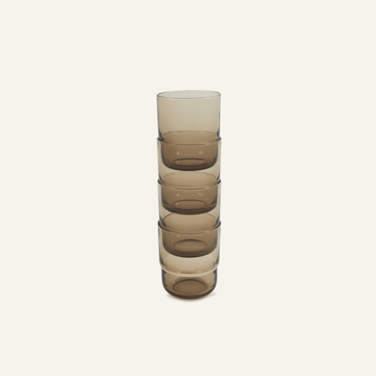A stack of five Short Night + Day Glasses made from brown-tinted recycled glass is neatly arranged against a plain light background, highlighting their modern, versatile design.