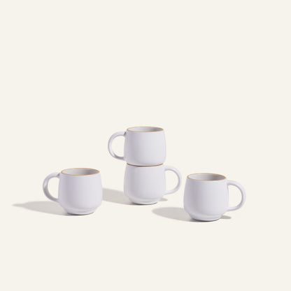 Four Night + Day Mugs, crafted from white ceramic stoneware, are stacked in pairs and displayed on a plain light background.