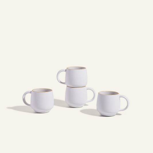 Four Night + Day Mugs, crafted from white ceramic stoneware, are stacked in pairs and displayed on a plain light background.