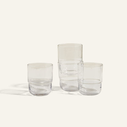 Three Short Night + Day Glasses, handmade from recycled glass, are displayed on a light background—two side by side and the third stacked on top.