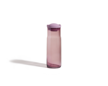 The Night + Day Carafe is a tall, translucent pink water bottle with a matching pink screw-on lid, ideal for pairing with your carafe or cold brew infuser for refreshing drinks wherever you go.