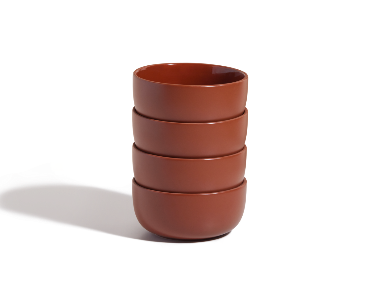 A stack of four brown Soup Bowls with a ceramic finish rests on a white background, casting a soft left shadow—an elegant upgrade to your tableware collection.