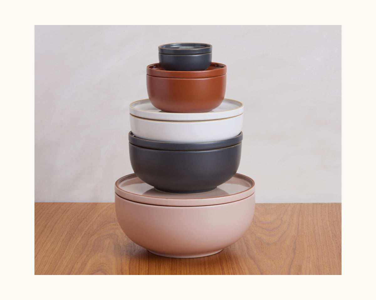Set of five vibrant Serving Bowls in assorted sizes, stacked on a wooden surface with a neutral backdrop—ideal stackable tableware to enhance any kitchen.