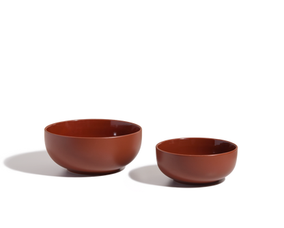 Two brown Serving Bowls of different sizes are placed side by side on a white surface with soft shadows, ideal as salad bowls or stackable tableware.