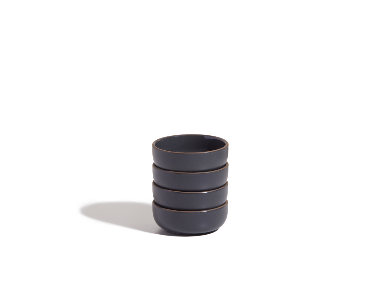 A stack of four Tiny Bowls, made from scratch-resistant ceramic, is arranged on a plain white background and casts a shadow to the left.