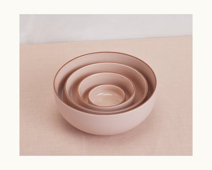 Four Tiny Bowls in pink ceramic, each a different size, are stacked on soft pink fabric—showcasing elegant, stylish, and practical stackable tableware.