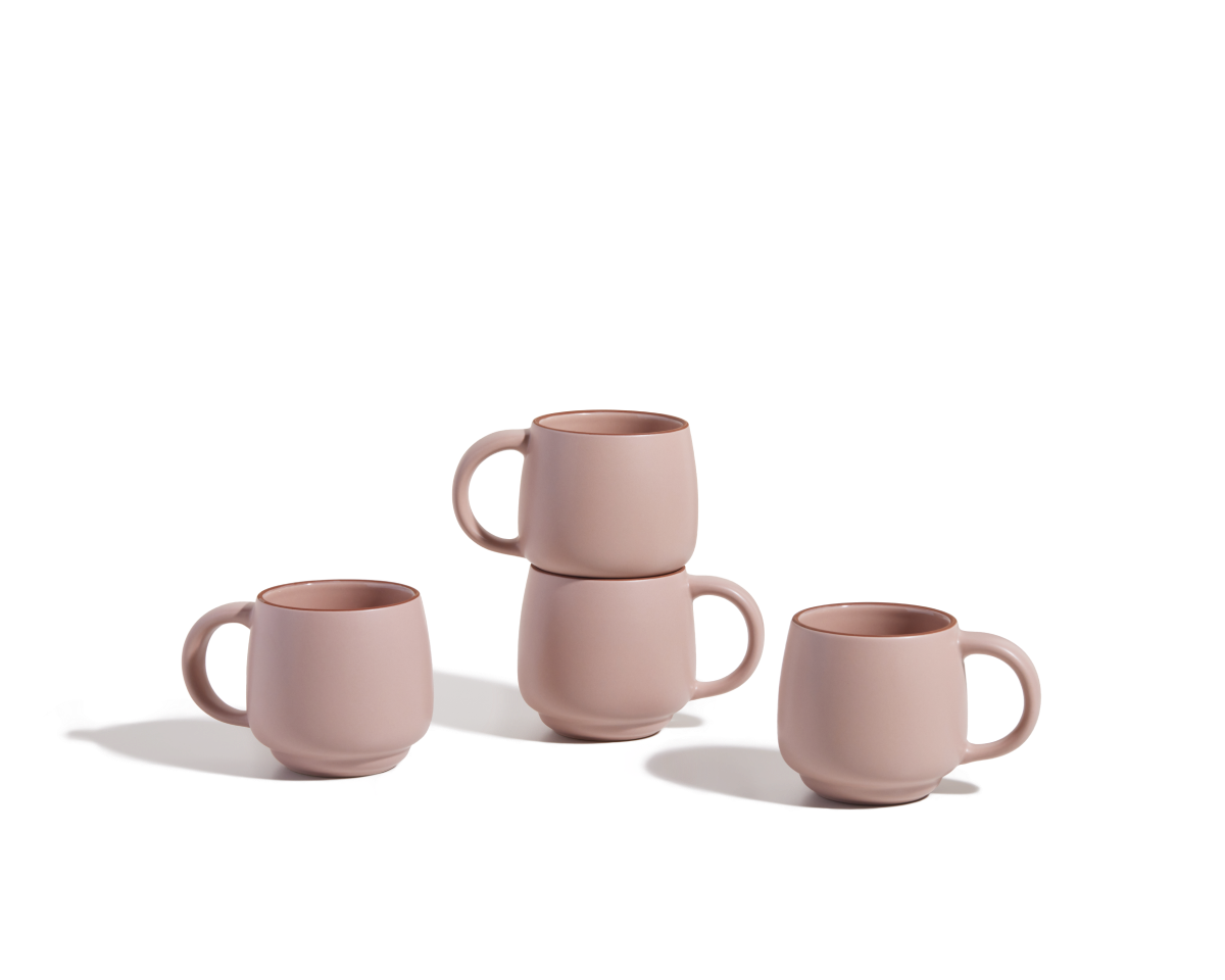 Four Night + Day Mugs in pink ceramic stoneware—two upright, two stacked—are displayed on a white background. These stackable mugs offer ample capacity for enjoying your favorite drinks.