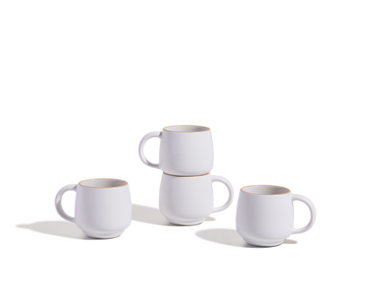Four Night + Day Mugs, made of white ceramic stoneware, are displayed on a plain white surface—two mugs stacked and the other two placed next to them.
