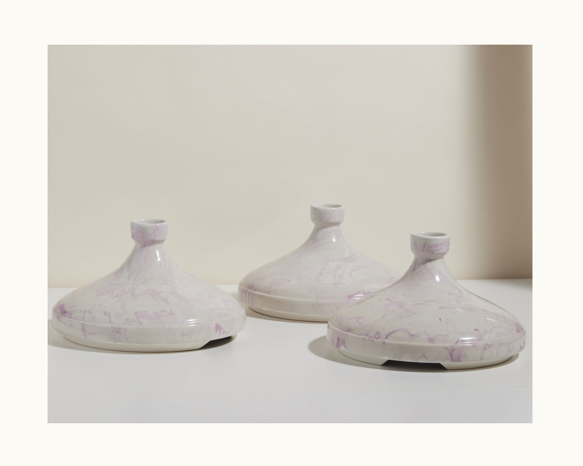 Three pale, marbled clay Tagine pots with short necks are arranged on a white surface against a neutral background—ideal for slow cooking and bringing handcrafted Moroccan flavor to your kitchen.