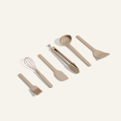 Utensil Essentials is a set of six beige cooking tools—pastry brush, whisk, spatula, tongs, ladle, and slotted spatula—arranged on a light background and ideal for everyday use in the kitchen.