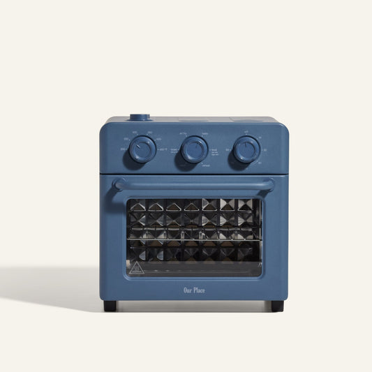 The AU - Wonder Oven is a blue toaster oven with air fryer functionality, three control knobs, and a diamond-patterned glass door, shown against a plain light background.