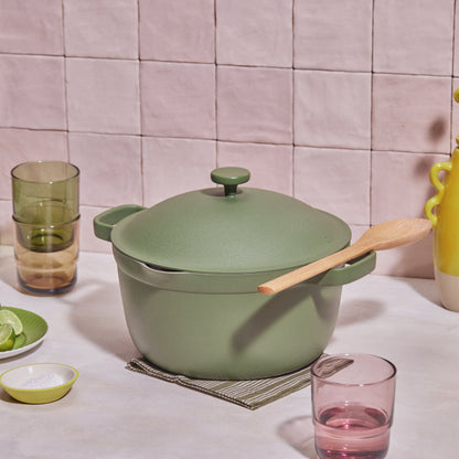 Green perfect pot non toxic nonstick dutch oven resting on a table next to drinking glasses