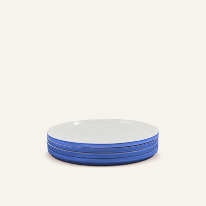 A set of four Main Plates, crafted from white porcelain with blue edges, neatly stacked against a simple light background.