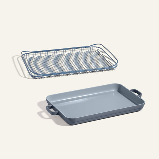 The Oven Rack + Griddle Pan set includes a rectangular matte blue-gray pan with handles and a matching metal rack that fits above it.