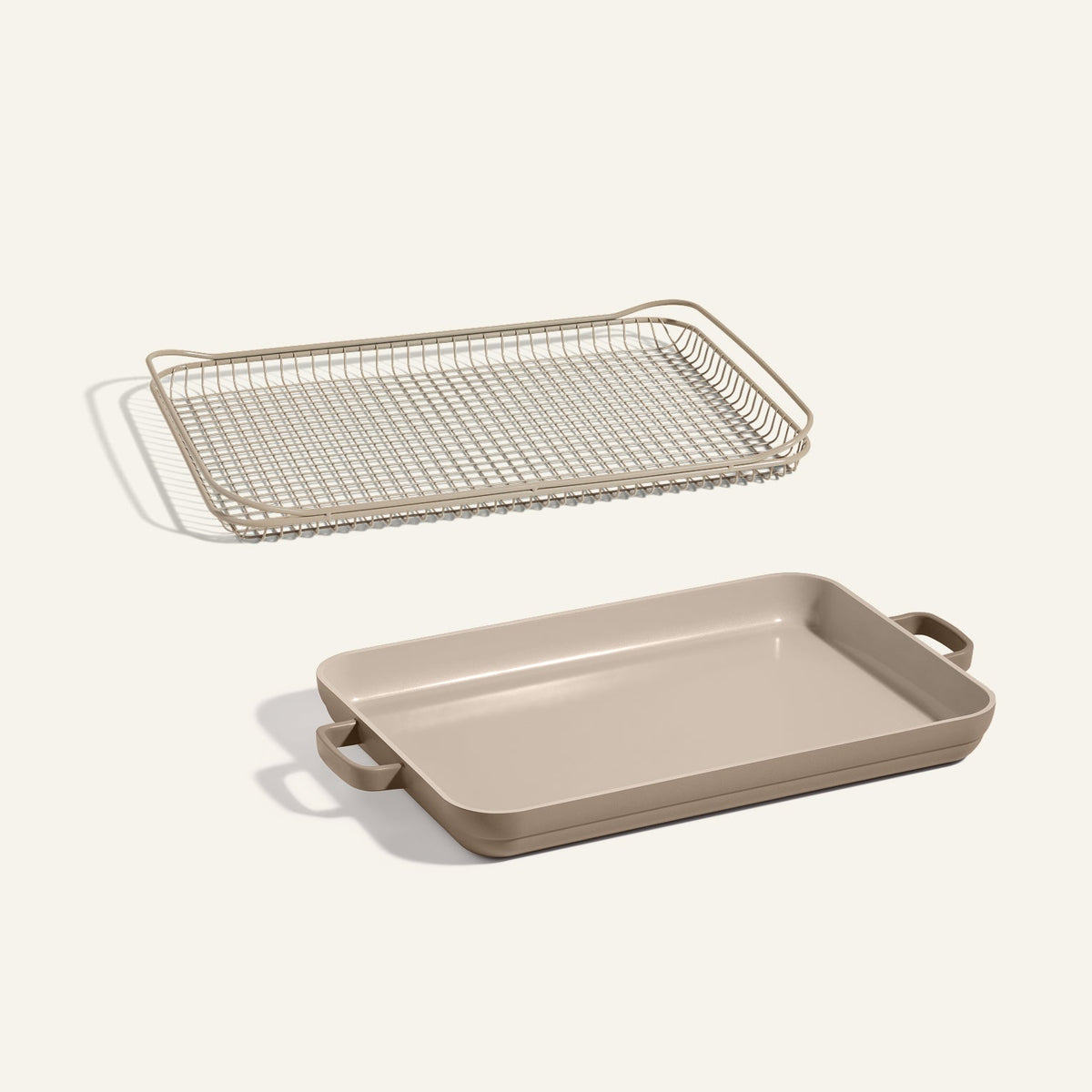 The Oven Rack + Griddle Pan set, featuring a beige rectangular pan with handles, is displayed beneath its matching wire rack against a plain light background.