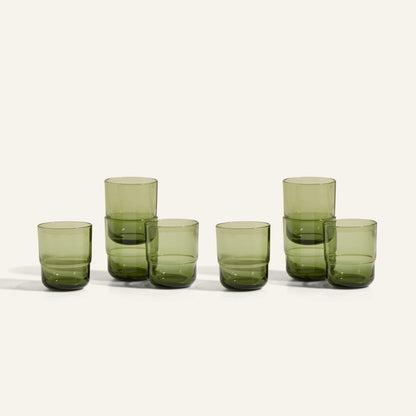 Six Short Night + Day Glasses in green recycled glass are arranged in two stacks of two and two singles, all set on a plain off-white background.