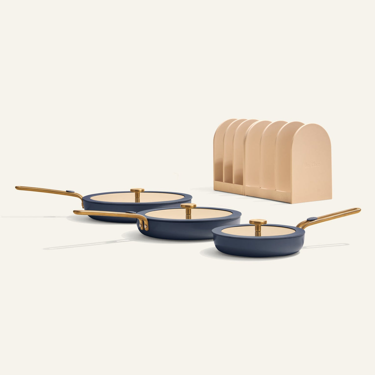 Set of three blue frying pans with gold handles on a white background