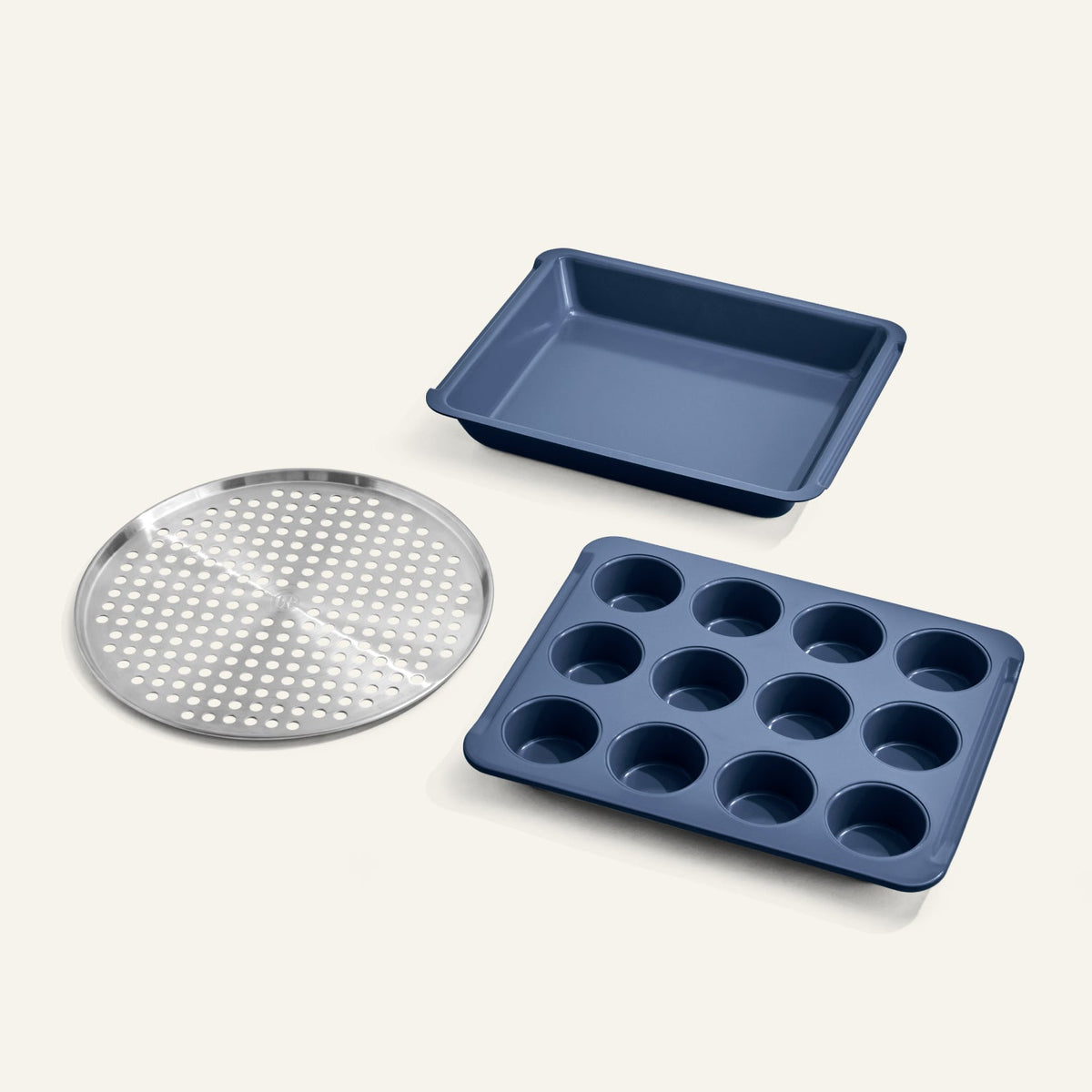 Set of blue baking trays including a muffin tray, pizza stone, and square pan on a white background