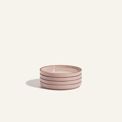 This stack of four round, light pink Dessert Plates with brown rims is scratch resistant and adds elegance to any table setting.