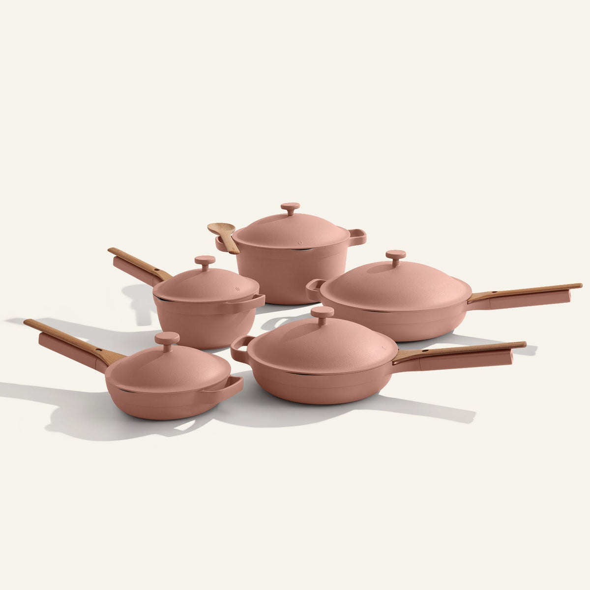 Set of pink cookware with lids on a white background